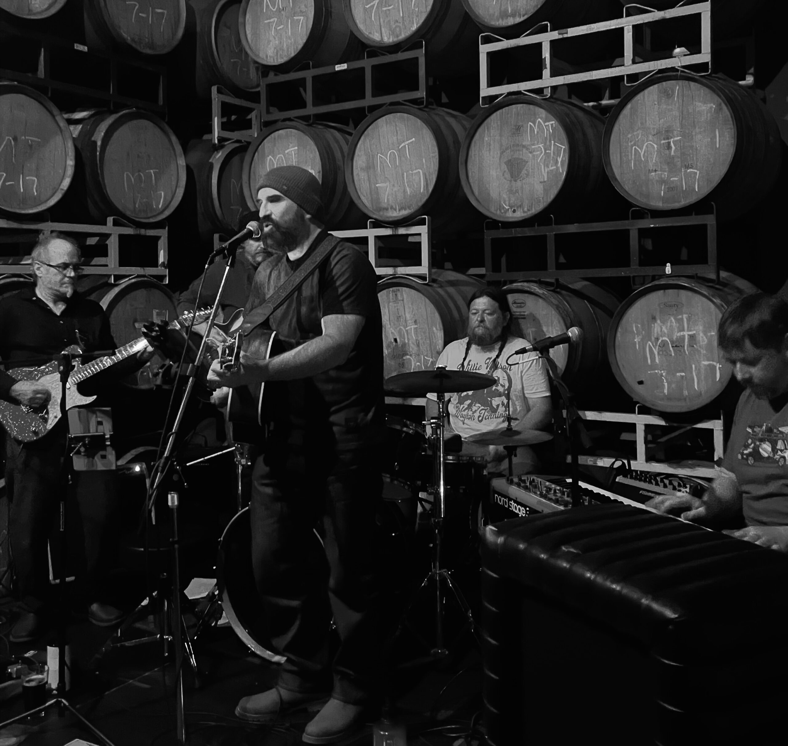 Parker Galactic performing live in front of a wall of wine barrels.